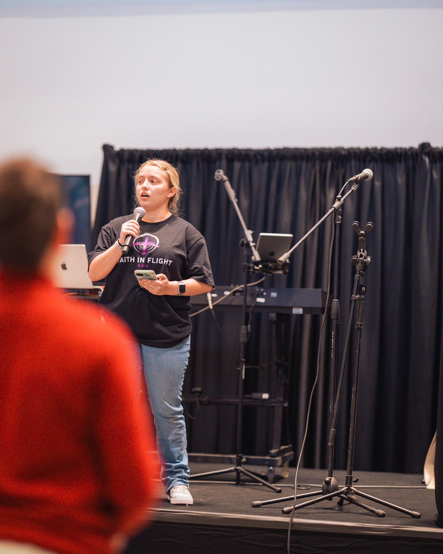 Student sharing testimony on stage