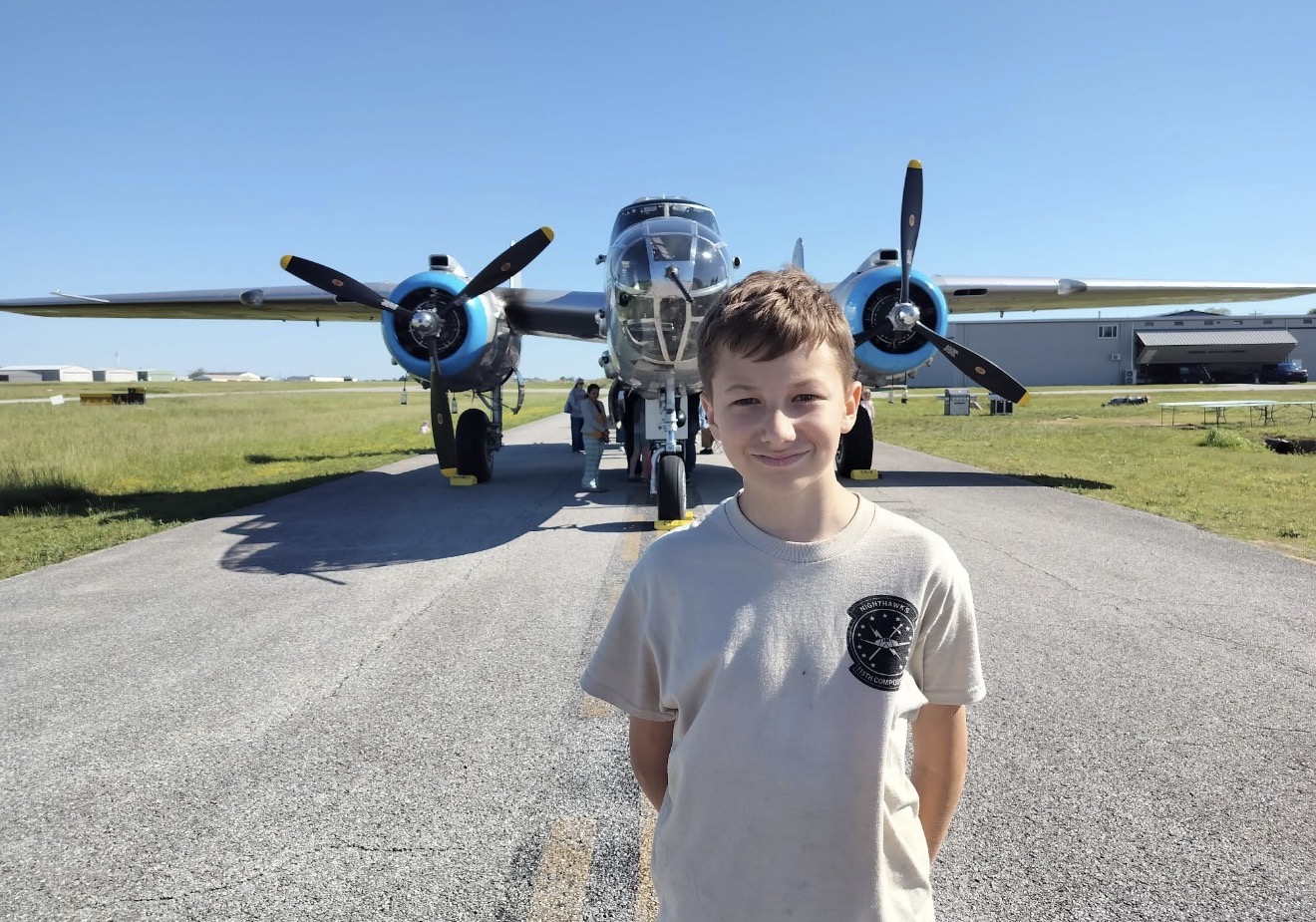 Young aviator in front of a vintage twin-engine aircraft