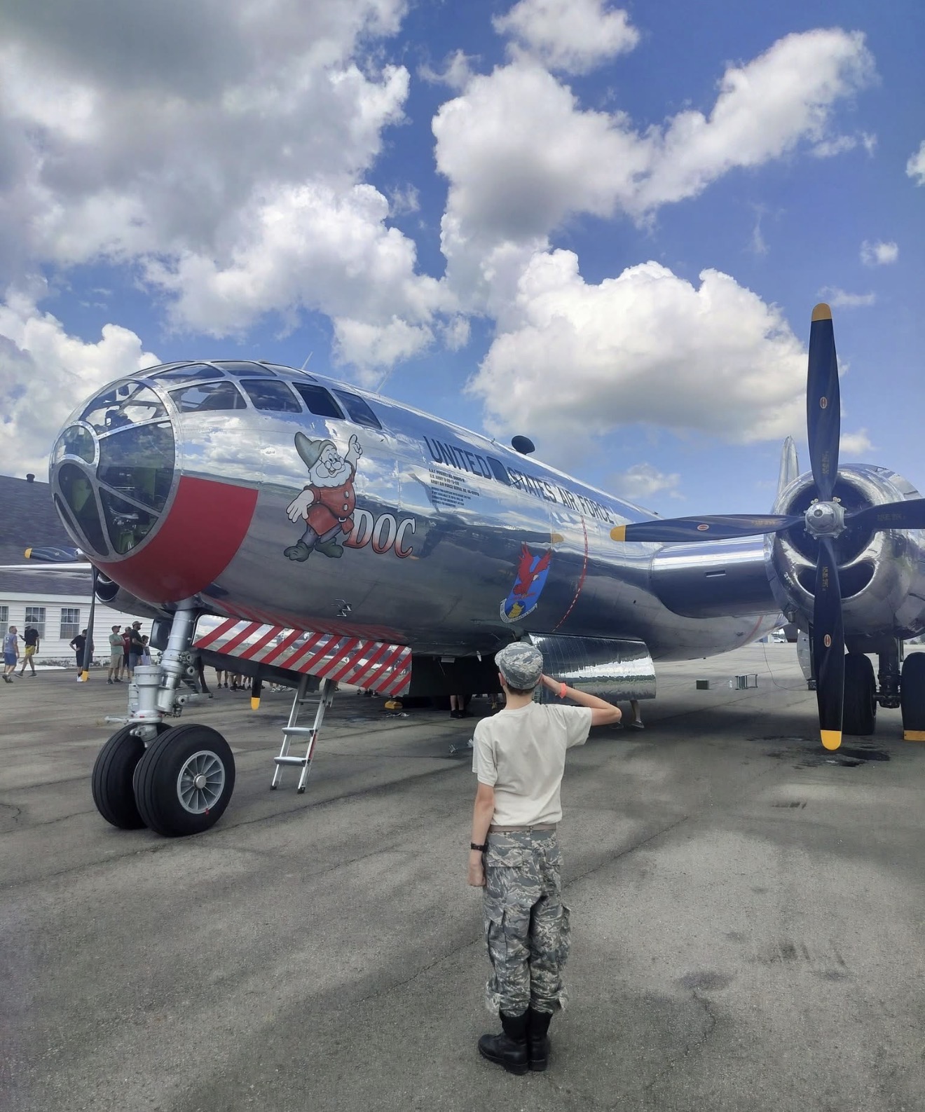 Young cadet saluting the B-29 Doc bomber