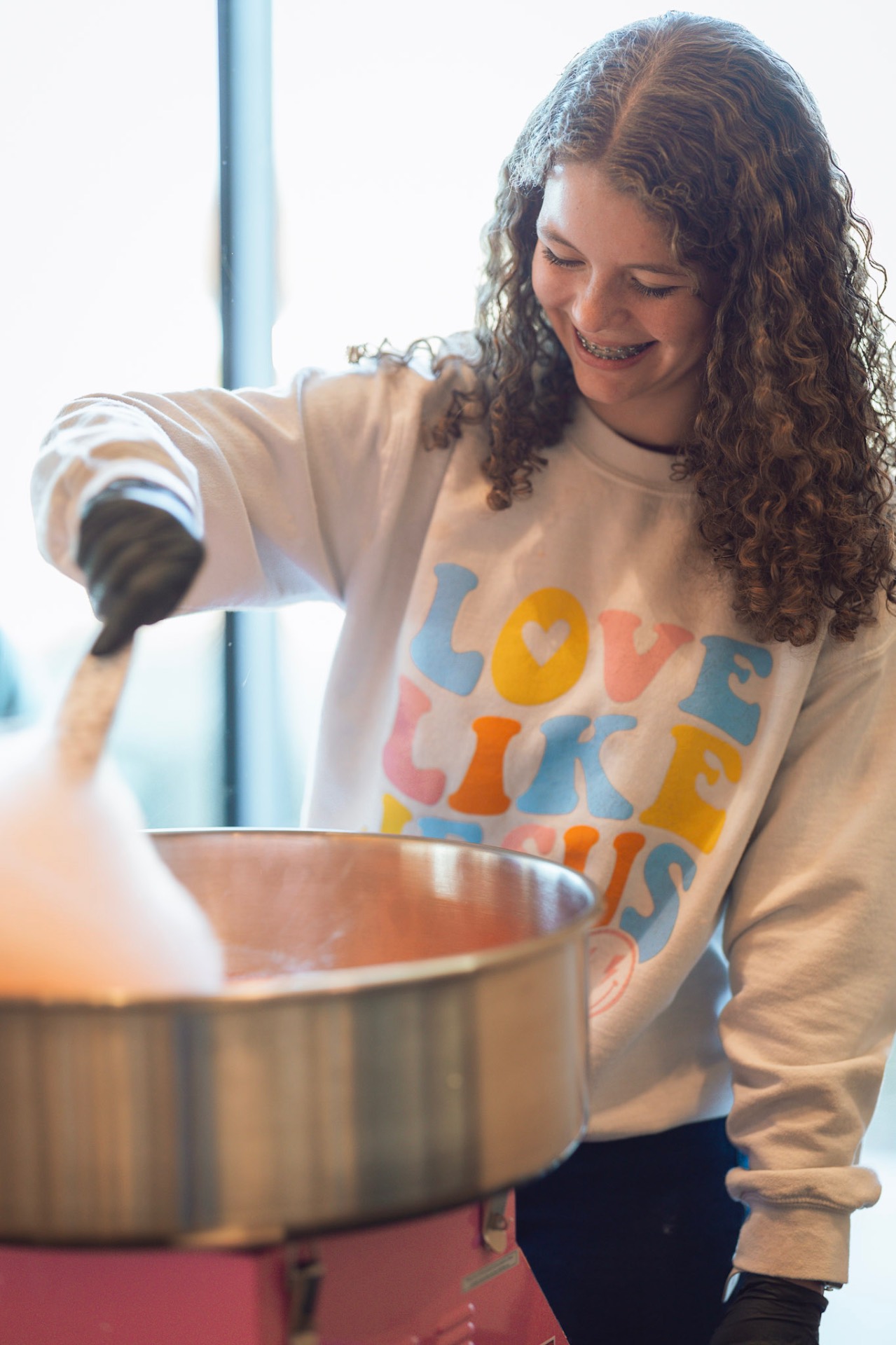 Volunteer making cotton candy for guests